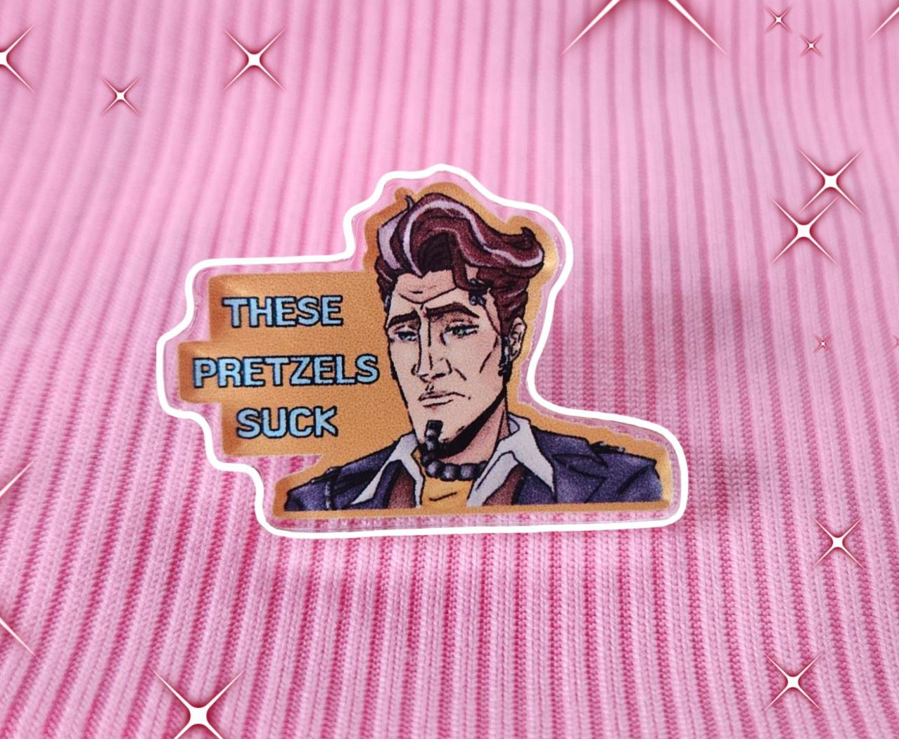 Acrylic pin with a character design and text on a pink background